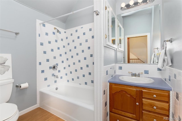 full bathroom with backsplash, tiled shower / bath combo, vanity, wood-type flooring, and toilet