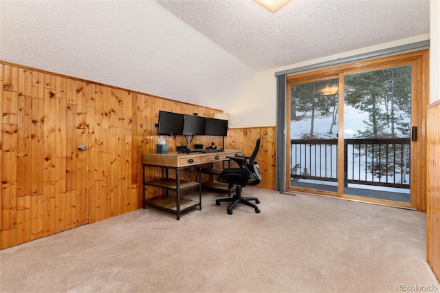 office featuring vaulted ceiling, carpet flooring, a textured ceiling, and wood walls