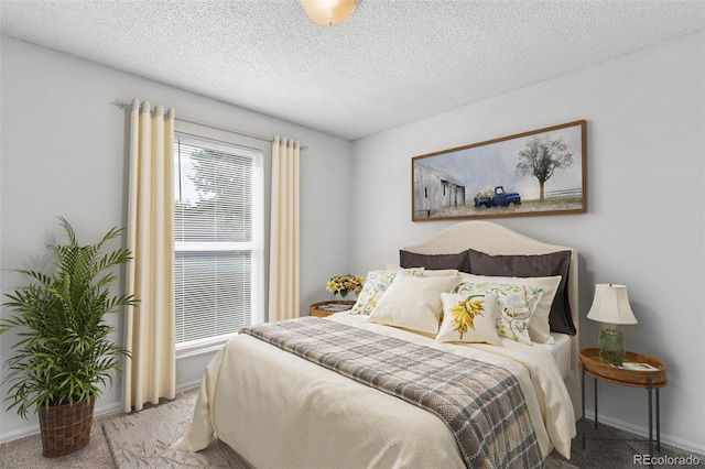 bedroom with light colored carpet and a textured ceiling