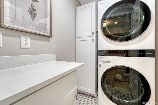 10289 E Berry Dr, Greenwood Village, CO 80111 - laundry room with stacked washer / drying machine and cabinet space