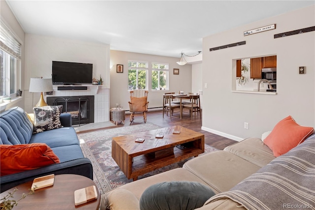 living room featuring dark hardwood / wood-style flooring and a tile fireplace