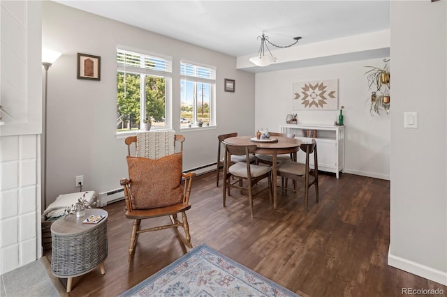 dining space with a baseboard heating unit and dark hardwood / wood-style floors