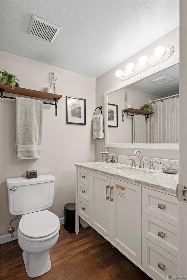 bathroom featuring vanity, hardwood / wood-style floors, and toilet