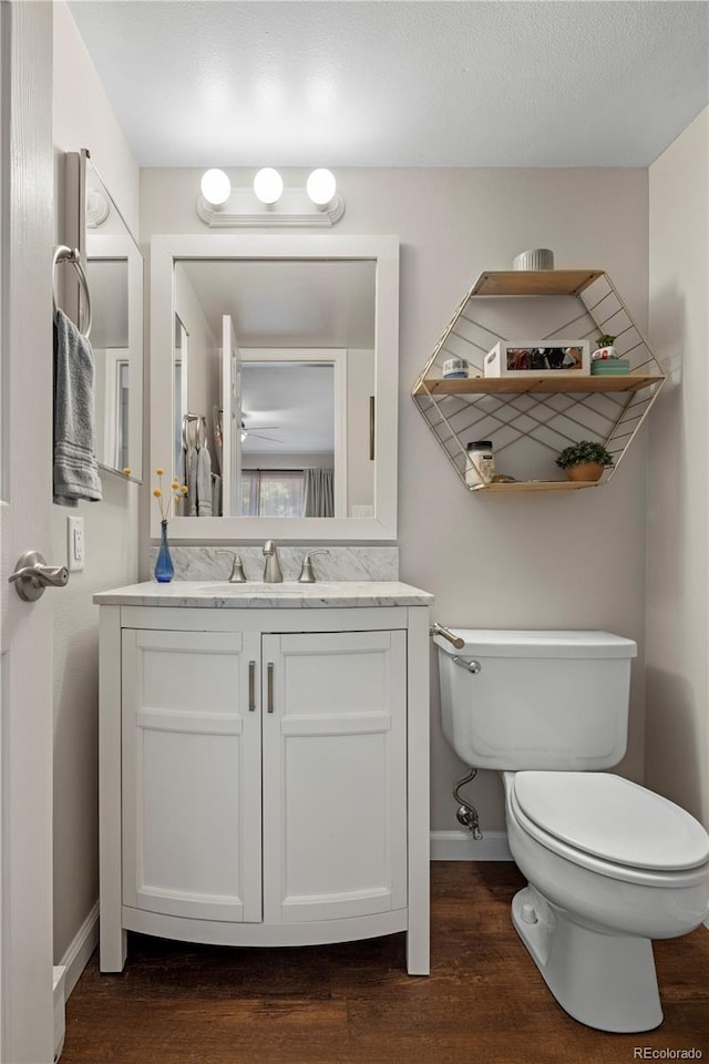 bathroom with vanity, toilet, hardwood / wood-style floors, and a textured ceiling