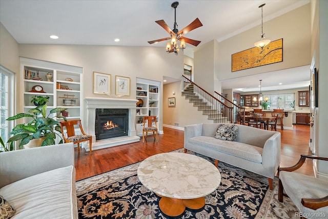 4545 S Monaco St Unit 243, Denver, CO 80237 - living area featuring stairway, wood finished floors, built in features, a high end fireplace, and high vaulted ceiling