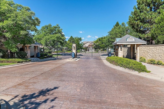4545 S Monaco St Unit 243, Denver, CO 80237 - view of decorative street featuring a gate, curbs, and a gated entry
