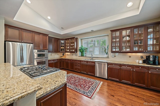 4545 S Monaco St Unit 243, Denver, CO 80237 - kitchen with stainless steel appliances, a sink, light stone countertops, wood finished floors, and recessed lighting