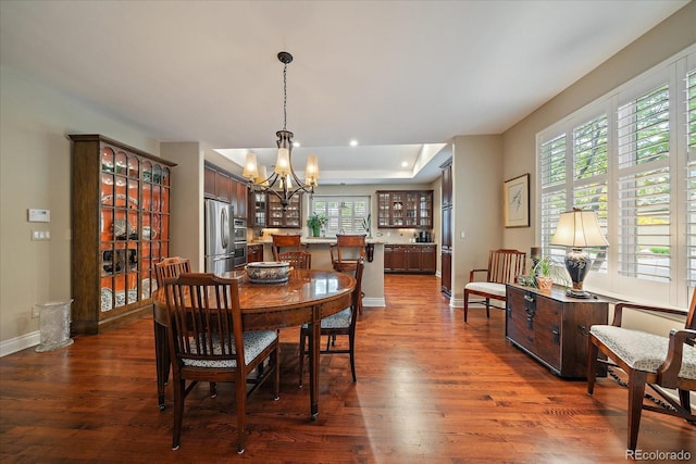 4545 S Monaco St Unit 243, Denver, CO 80237 - dining area featuring a chandelier, dark wood-style flooring, a raised ceiling, baseboards, and recessed lighting