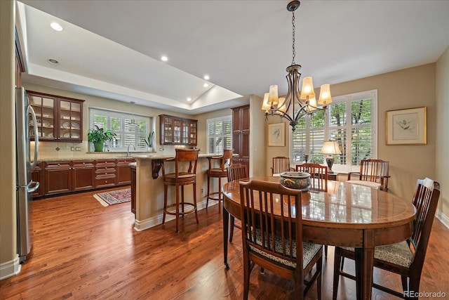 4545 S Monaco St Unit 243, Denver, CO 80237 - dining space with wood finished floors, healthy amount of natural light, a tray ceiling, a chandelier, and recessed lighting