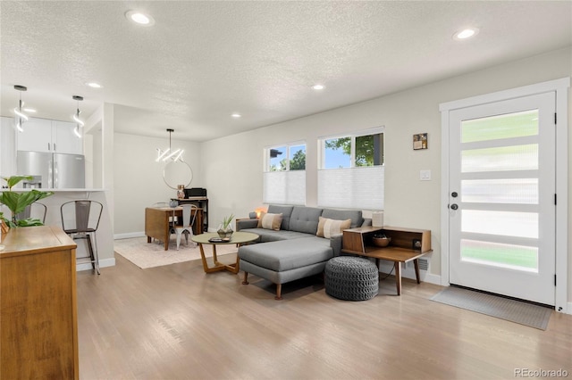 2313 S Raleigh St, Denver, CO 80219 - living area with light wood-style flooring, a textured ceiling, and recessed lighting