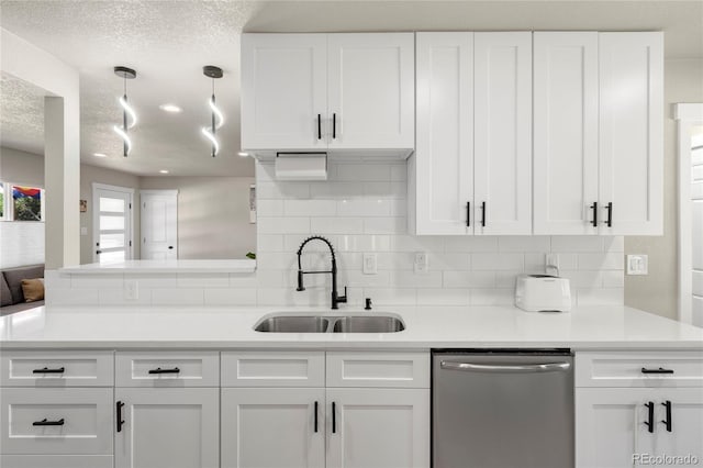 2313 S Raleigh St, Denver, CO 80219 - kitchen featuring stainless steel dishwasher, white cabinets, tasteful backsplash, a peninsula, and light countertops