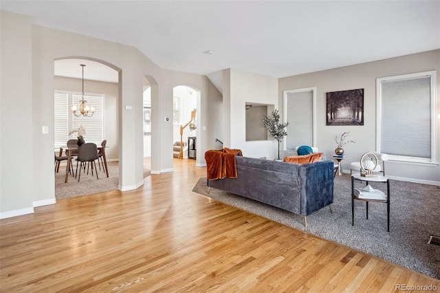 living room with light wood-type flooring and an inviting chandelier