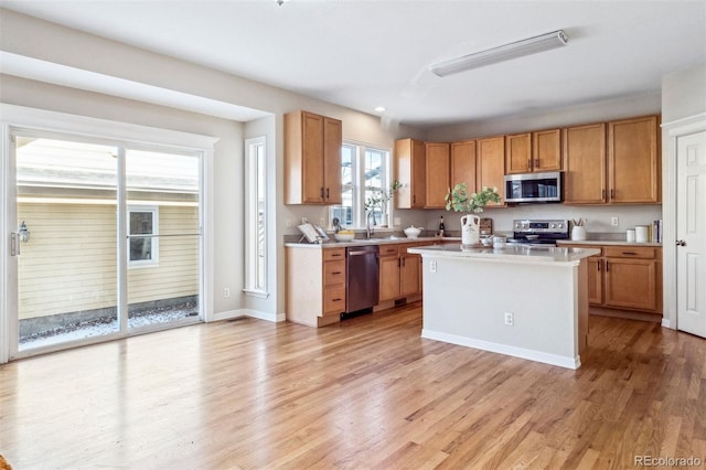 kitchen with a kitchen island, sink, stainless steel appliances, and light hardwood / wood-style flooring