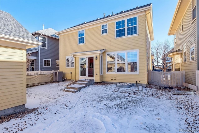 snow covered rear of property featuring central air condition unit