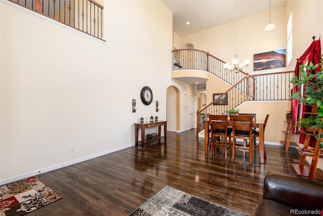 11460 W Tanforan Cir, Littleton, CO 80127 - dining room featuring arched walkways, stairs, a high ceiling, wood finished floors, and a chandelier