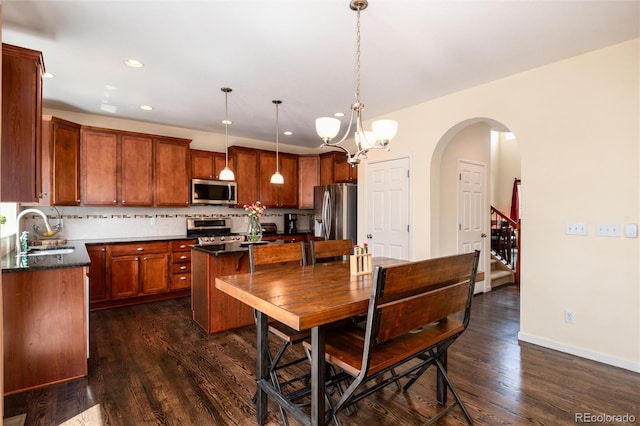 11460 W Tanforan Cir, Littleton, CO 80127 - dining space featuring dark wood-style floors, a chandelier, recessed lighting, arched walkways, and baseboards