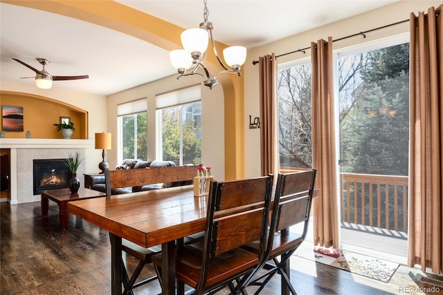11460 W Tanforan Cir, Littleton, CO 80127 - dining area featuring wood finished floors, a chandelier, a ceiling fan, and a tiled fireplace