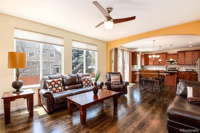 11460 W Tanforan Cir, Littleton, CO 80127 - living area with arched walkways, dark wood-style floors, and ceiling fan