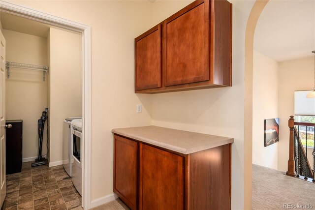 11460 W Tanforan Cir, Littleton, CO 80127 - kitchen with brown cabinetry, light countertops, arched walkways, baseboards, and stone finish flooring