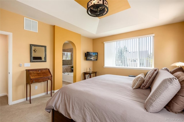 11460 W Tanforan Cir, Littleton, CO 80127 - bedroom featuring arched walkways, a tray ceiling, light carpet, baseboards, and connected bathroom
