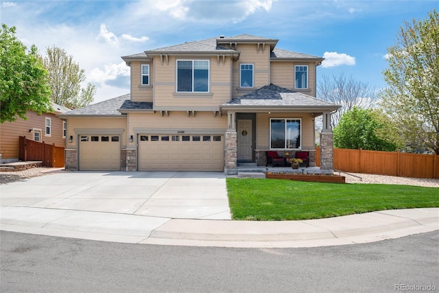 11460 W Tanforan Cir, Littleton, CO 80127 - view of front of property featuring covered porch, concrete driveway, stone siding, and an attached garage
