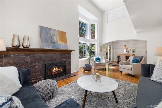 5922 E Briarwood Dr, Centennial, CO 80112 - living area featuring a towering ceiling, a tiled fireplace, wood finished floors, and arched walkways