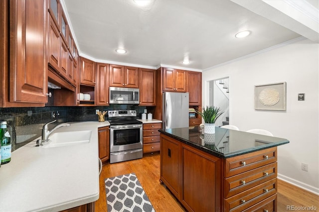 5922 E Briarwood Dr, Centennial, CO 80112 - kitchen with appliances with stainless steel finishes, tasteful backsplash, light wood-type flooring, ornamental molding, and a kitchen island