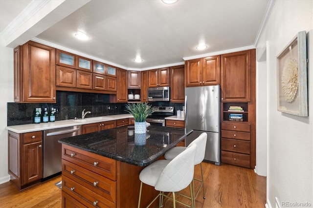 5922 E Briarwood Dr, Centennial, CO 80112 - kitchen featuring stainless steel appliances, light wood-type flooring, backsplash, a breakfast bar, and ornamental molding