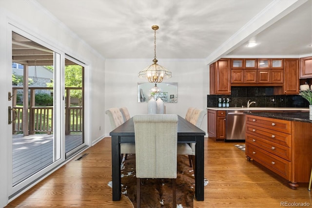 5922 E Briarwood Dr, Centennial, CO 80112 - dining space featuring a chandelier, wood finished floors, and crown molding