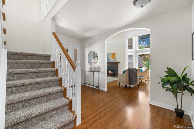 5922 E Briarwood Dr, Centennial, CO 80112 - entryway with stairs, wood finished floors, a lit fireplace, and arched walkways