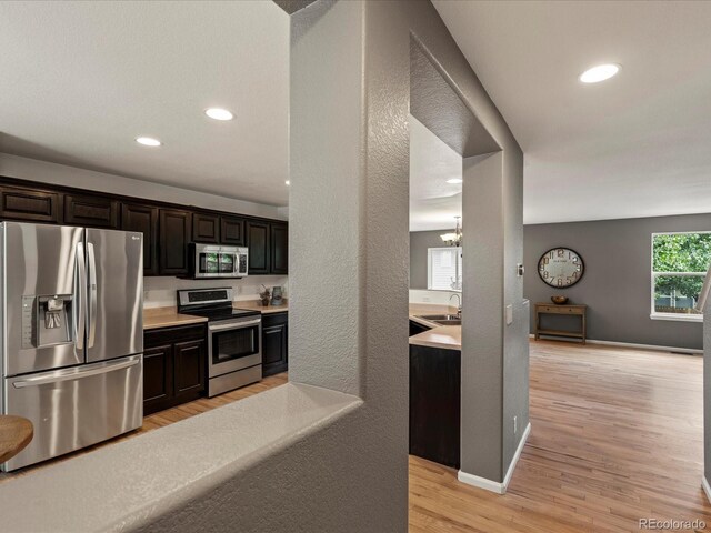 11082 Fillmore Way, Northglenn, CO 80233 - kitchen with stainless steel appliances, light wood-type flooring, light countertops, recessed lighting, and a chandelier
