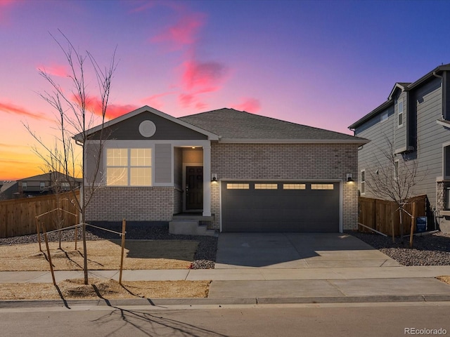 view of front of property with concrete driveway, a garage, fence, and brick siding