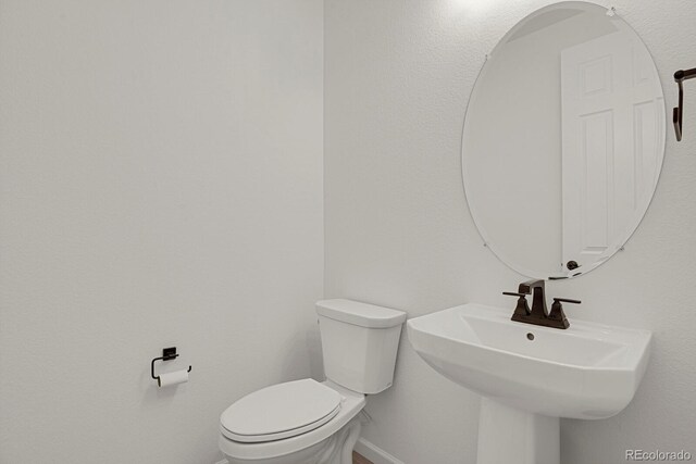 7325 S Waterloo Way, Aurora, CO 80016 - bathroom featuring toilet, baseboards, and a sink