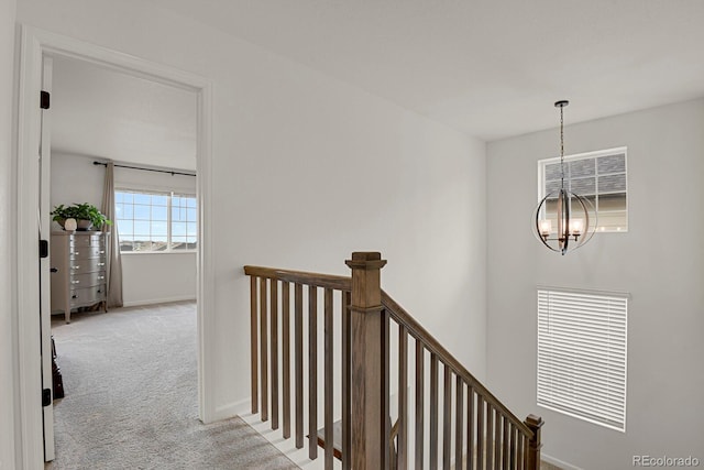 7325 S Waterloo Way, Aurora, CO 80016 - corridor featuring an upstairs landing, a chandelier, carpet flooring, and baseboards