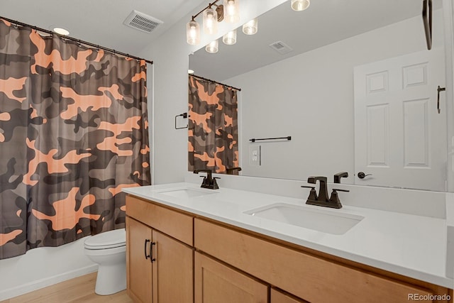 7325 S Waterloo Way, Aurora, CO 80016 - bathroom featuring toilet, double vanity, wood finished floors, and shower / tub combo