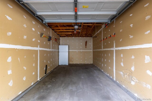 8707 E Florida Ave Unit 614, Denver, CO 80247 - garage featuring freestanding refrigerator and a garage door opener