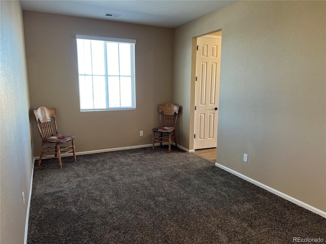 unfurnished room with dark colored carpet