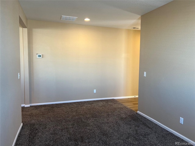 empty room with dark colored carpet