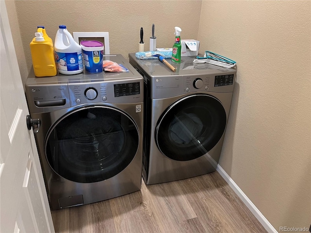 laundry area with hardwood / wood-style flooring and washer and dryer