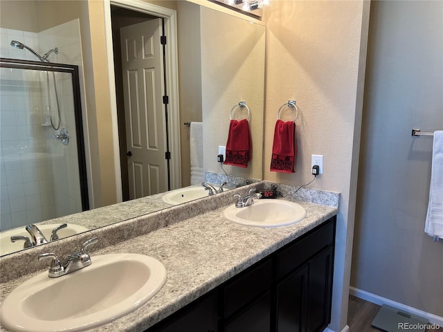 bathroom with walk in shower, vanity, and wood-type flooring