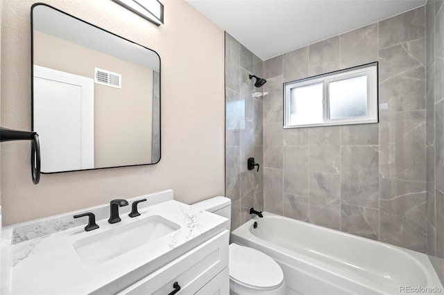 full bathroom with tiled shower / bath combo, toilet, and vanity