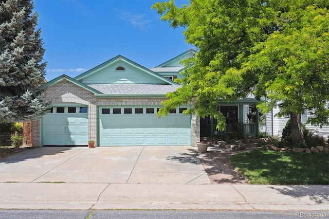 12963 W 84th Pl, Arvada, CO 80005 - view of front of house with an attached garage, driveway, brick siding, and roof with shingles
