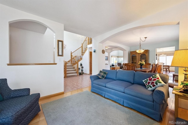 12963 W 84th Pl, Arvada, CO 80005 - living area featuring arched walkways, wood finished floors, and stairs