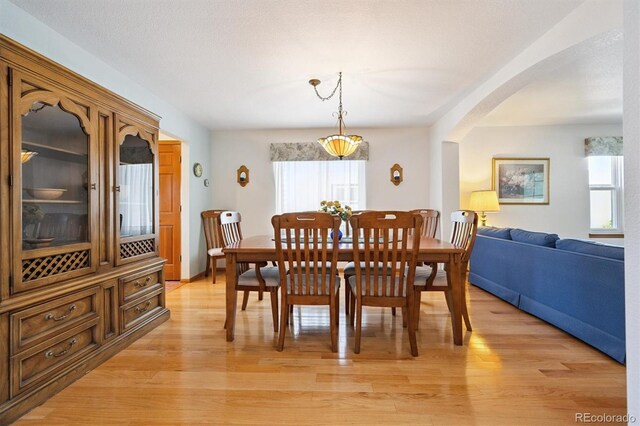 12963 W 84th Pl, Arvada, CO 80005 - dining space with healthy amount of natural light, light wood finished floors, and arched walkways