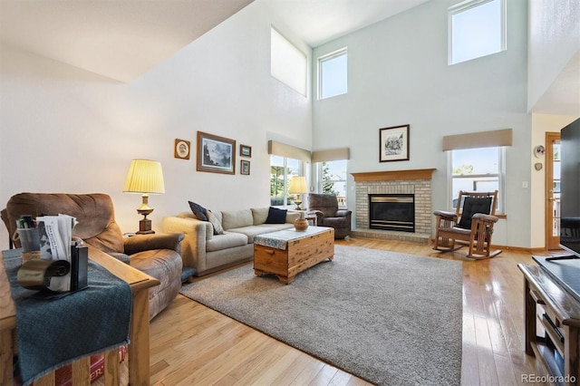 12963 W 84th Pl, Arvada, CO 80005 - living room featuring light wood finished floors, a fireplace, and a high ceiling