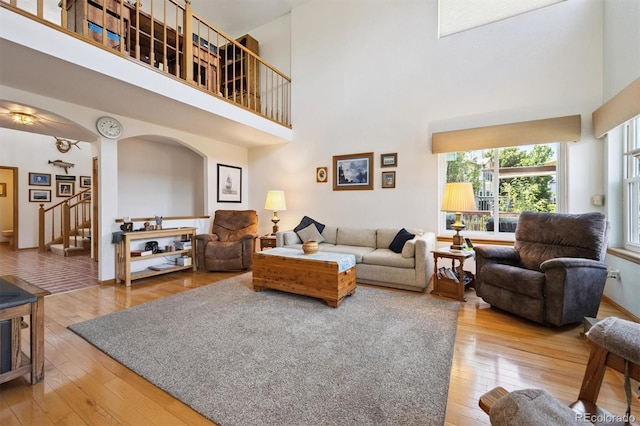 12963 W 84th Pl, Arvada, CO 80005 - living room with hardwood / wood-style floors, a high ceiling, stairway, and arched walkways