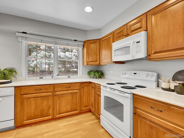 5895 W Plymouth Dr, Littleton, CO 80128 - kitchen featuring white appliances, brown cabinets, light countertops, light wood-style flooring, and recessed lighting