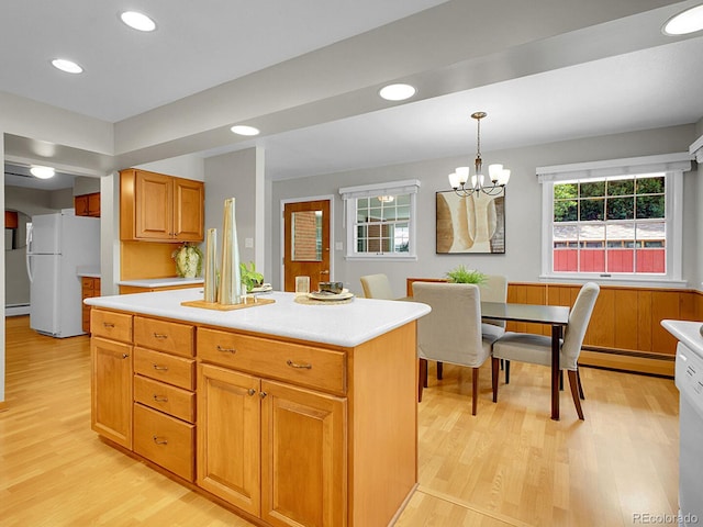 5895 W Plymouth Dr, Littleton, CO 80128 - kitchen featuring freestanding refrigerator, light wood-style flooring, light countertops, pendant lighting, and recessed lighting
