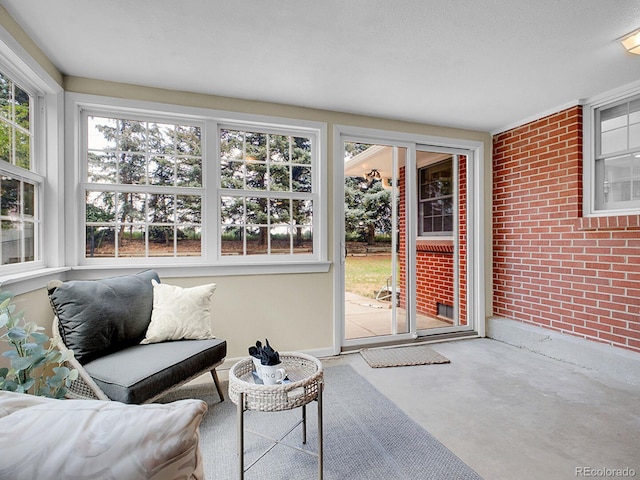 5895 W Plymouth Dr, Littleton, CO 80128 - sunroom / solarium featuring healthy amount of natural light, brick wall, and concrete flooring