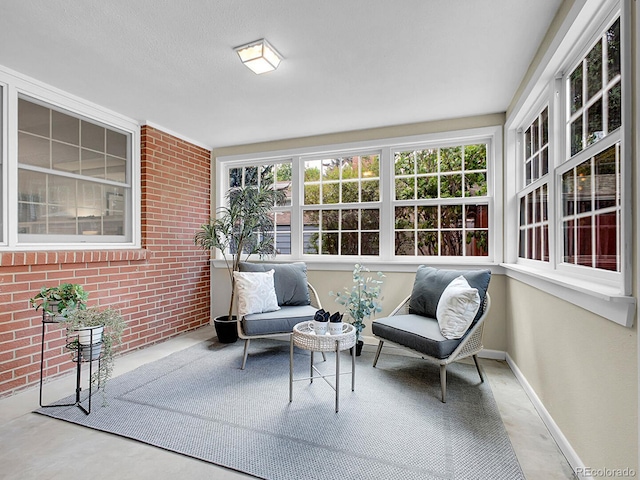 5895 W Plymouth Dr, Littleton, CO 80128 - sunroom with brick wall and concrete floors